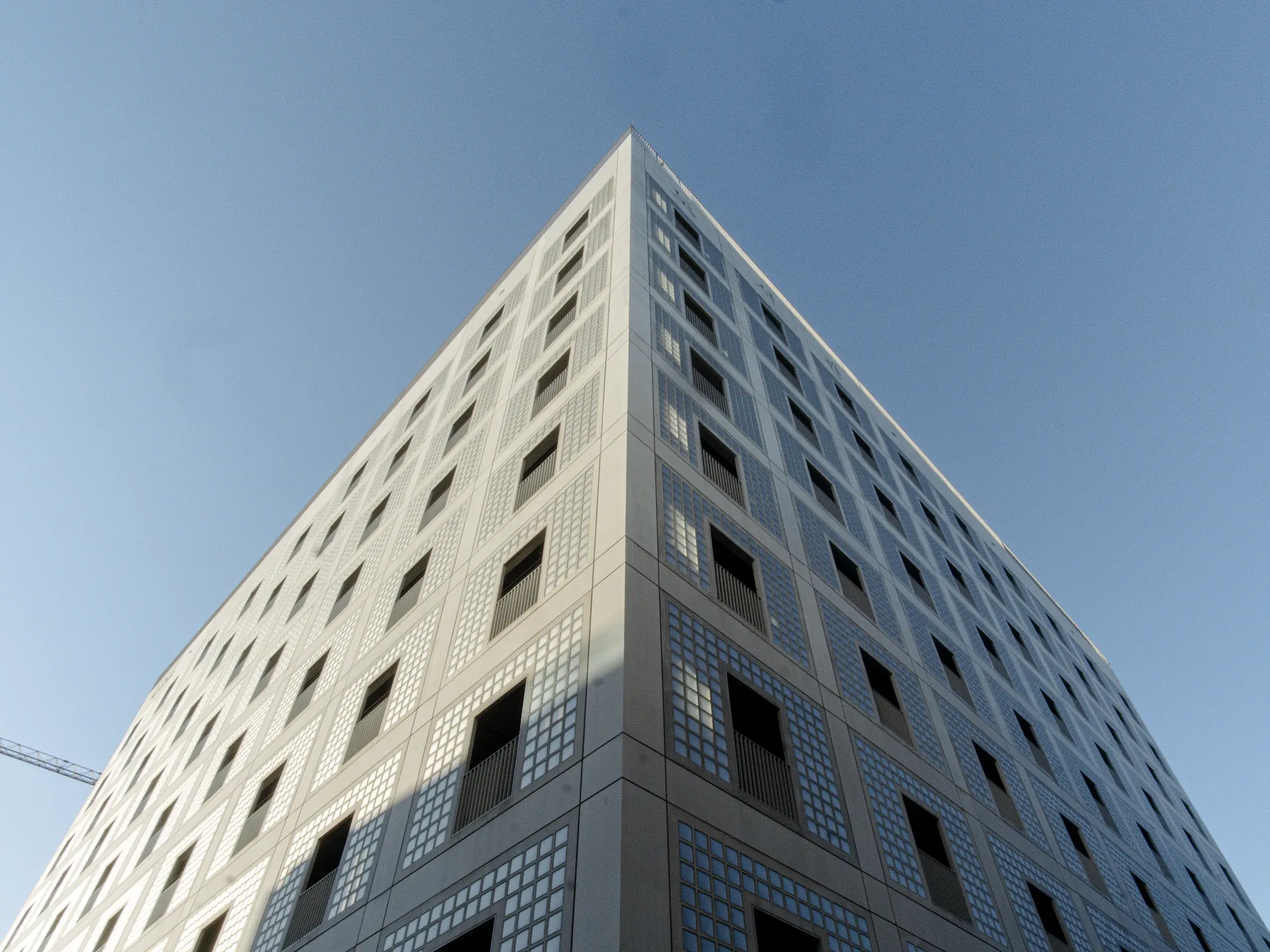 A geometric stone facade viewed against an open sky